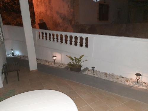 una stanza con una parete bianca con due luci e una pianta di Apartmani Ana-Lora a Lopar