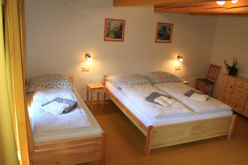 1 dormitorio con 2 camas individuales y espejo en Urbársky dom, en Liptovský Ján