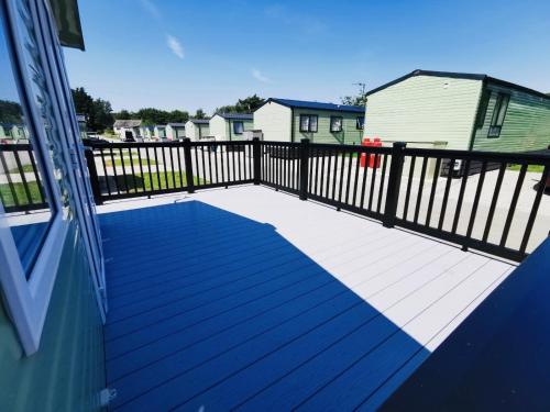 a deck with a black fence and a house at 12 Borwick Lakes- Newly Refurbished in Carnforth