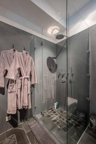a bathroom with a glass shower stall with towels at GOING TRIPLE A apartments NORTH in Going