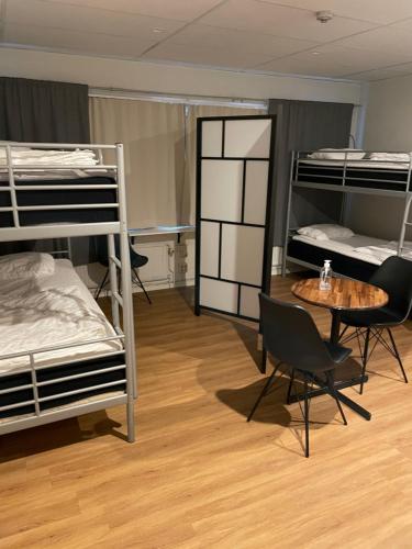 a room with a table and chairs and bunk beds at Uppsala City Hostel in Uppsala