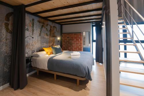 1 dormitorio con cama y pared de ladrillo en Loft con carácter en Valencia. en Valencia