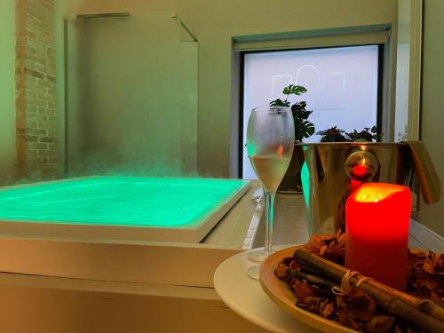 a hot tub with a glass of wine and a candle at Residenza Palazzo Fortuna - Boutique Hotel in Civita Castellana