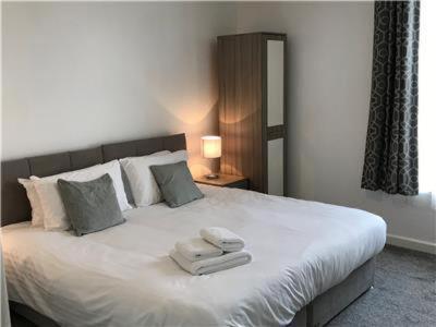 a bedroom with a large white bed with towels on it at Upper Ashby Apartments in Brumby