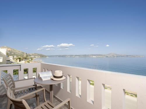 d'un balcon avec une table et des chaises donnant sur l'océan. dans l'établissement Porto Kalyves Seaside Aparthotel, à Kalyves