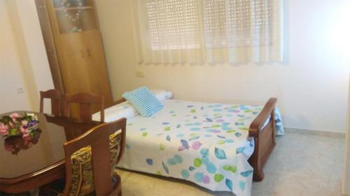 a small bedroom with a bed and a chair at Luz de Carboneras in Carboneras de Guadazaón