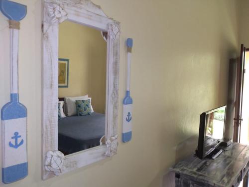a mirror on a wall with a bed in a room at Pousada da Terra Paraty in Paraty