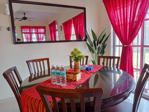 mesa de comedor con mantel rojo en Homestay Camelia Kuala Terengganu Seberang Takir - Near Drawbridge en Kuala Terengganu