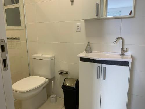 a small bathroom with a toilet and a sink at Praia Grande (12) - 3 quartos - 1 quadra Mar in Torres