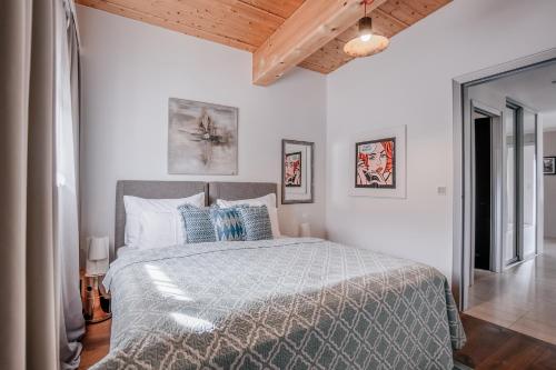 a white bedroom with a bed with blue pillows at GOING TRIPLE A apartments NORTH in Going