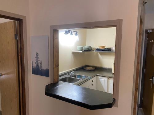 a small kitchen with a sink and a mirror at Western Lodge in Kimberley