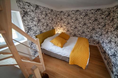 a small bedroom with a bed and a staircase at Bienvenue Chez Nous in Bergues