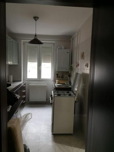 una piccola cucina con fornelli e finestra di APARTAMENT AUTENTIC RESIDENCE a Predeal