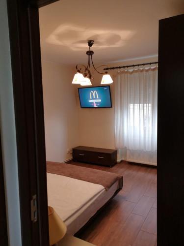 a bedroom with a bed and a tv on the wall at APARTAMENT AUTENTIC RESIDENCE in Predeal