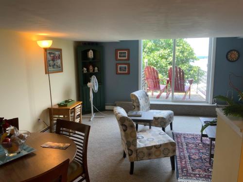 a living room with a table and chairs and a window at Chateau Country Inn and Captain's Cottage in Clayton