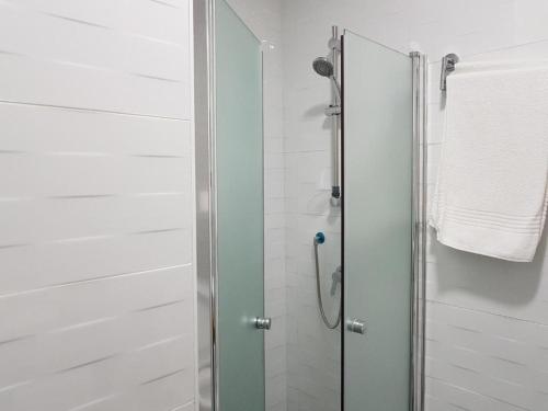 a shower with a glass door in a bathroom at Airport Guest House in Or Yehuda