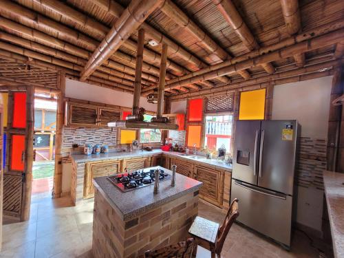 a large kitchen with wooden ceilings and a refrigerator at Chalet la texana in Filandia
