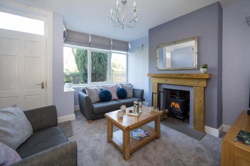 sala de estar con sofá y chimenea en Cherry Tree Villa, en Harrogate