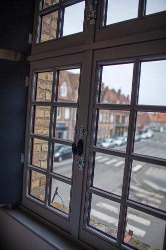 a glass door with a view of a street at Bienvenue Chez Nous in Bergues