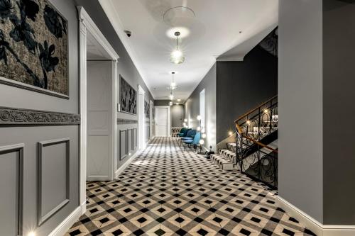 ペーチにあるPalatinus Boutique Hotelの白黒チェッカーの床の廊下