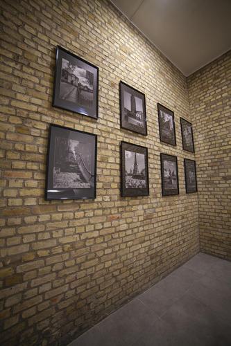 a brick wall with framed pictures on a wall at Bienvenue Chez Nous in Bergues