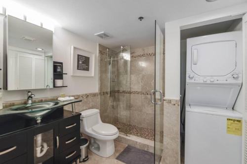 uma casa de banho com um chuveiro, um WC e um lavatório. em Centric Modern 40thFloor Brickell Condo FREE parking by Palermo Home Miami em Miami