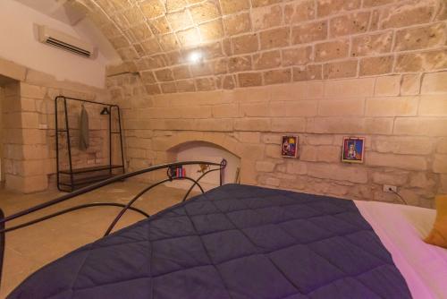 a bedroom with a bed in a stone wall at Suite dei Longobardi in Lecce