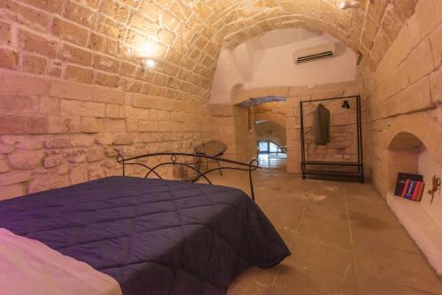 a bedroom with a bed in a stone wall at Suite dei Longobardi in Lecce
