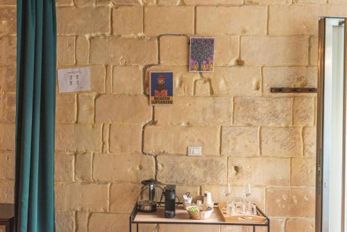 a stone wall with a table in front of a brick wall at Suite dei Longobardi in Lecce