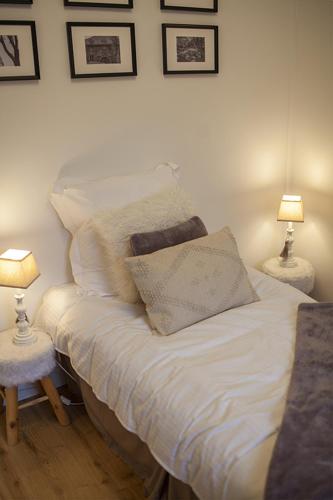 a white bed with two tables and two lamps at Bienvenue Chez Nous in Bergues