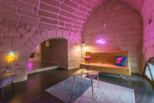 a room with a couch and a brick wall at Suite dei Longobardi in Lecce