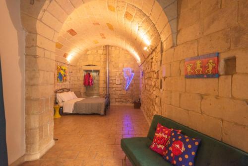 a hallway with a couch and a bed in a room at Suite dei Longobardi in Lecce