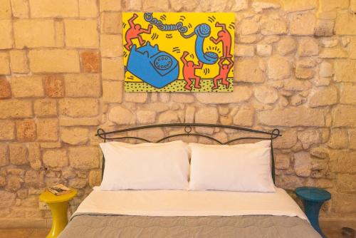 a bedroom with a bed and a painting on the wall at Suite dei Longobardi in Lecce