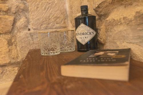 a book and a bottle and a glass on a table at Suite dei Longobardi in Lecce