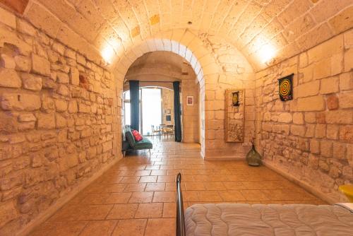 a hallway with an archway in a stone wall at Suite dei Longobardi in Lecce