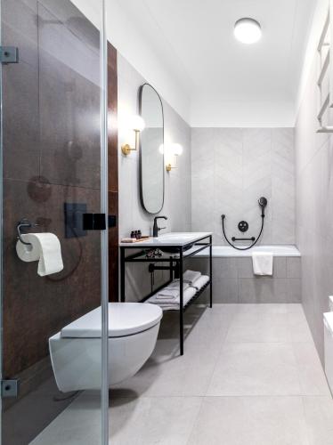 a bathroom with a shower and a toilet and a sink at Palatinus Boutique Hotel in Pécs