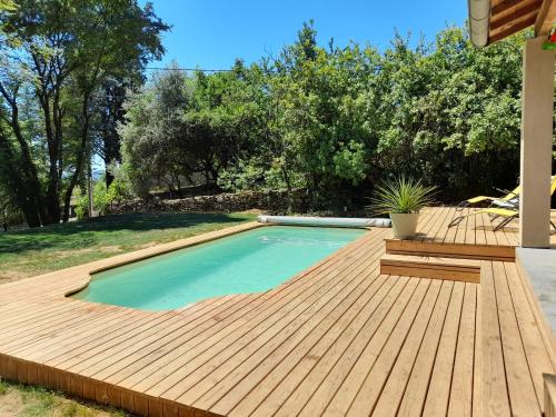une piscine avec une terrasse en bois à côté d'une arrière-cour dans l'établissement Charmante maison à Payzac Promos dernières dispo été, à Payzac
