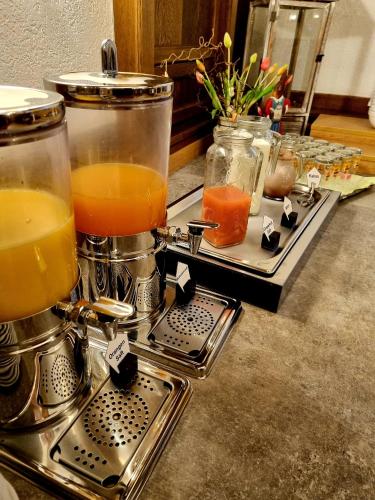 un mostrador con dos vasos de zumo de naranja en tarros en Hotel Gumberger GmbH Garni, en Neufahrn bei Freising