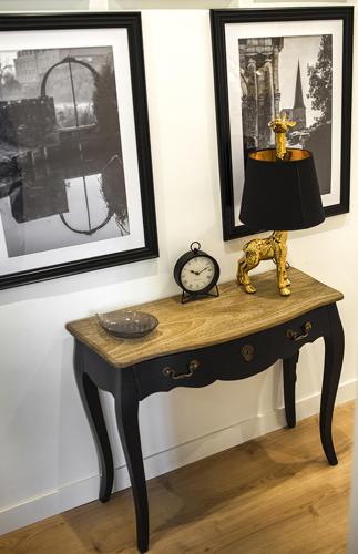 a table with a lamp and a clock on a wall at Bienvenue Chez Nous in Bergues