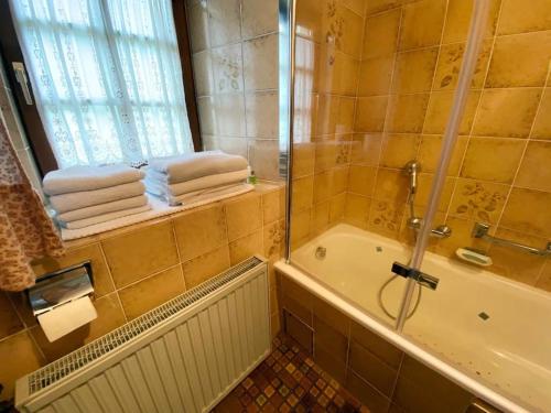 uma casa de banho com um chuveiro, uma banheira e toalhas em Denkmalgeschützter Bauernhof em Schauenstein