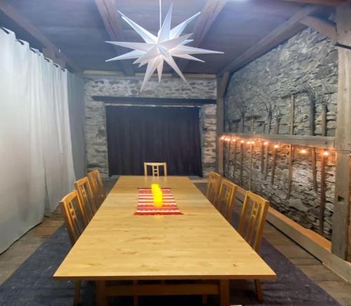 a dining room with a table with chairs and a chandelier at Denkmalgeschützter Bauernhof in Schauenstein