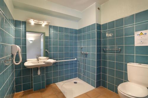 a blue tiled bathroom with a toilet and a sink at Vacancéole - Les Bastides de Fayence in Tourrettes