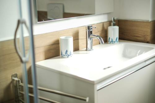 La salle de bains est pourvue d'un lavabo blanc et d'un miroir. dans l'établissement Rossani Suites&Aparts, à Bari