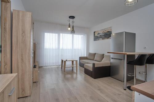 a kitchen and living room with a couch and a table at Apartament Słoneczny 11 in Opole
