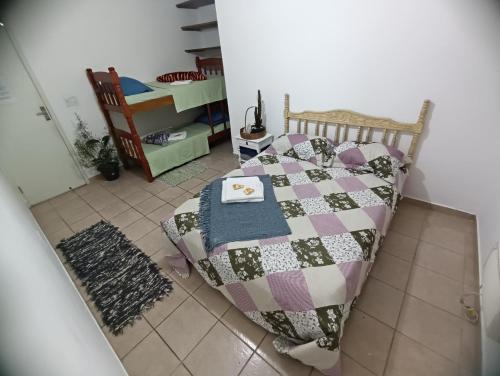 een slaapkamer met een bed met een quilt bij Hospedagem da Val in Paraty