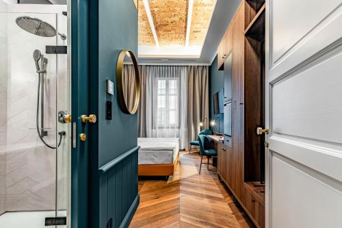 een kamer met een bed en een deur met een spiegel bij Palatinus Boutique Hotel in Pécs