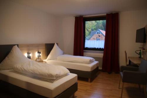 a hotel room with two beds and a window at Gasthaus Reinhardt in Alfeld