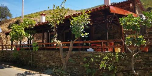 une maison avec un mur en pierre devant elle dans l'établissement Ferradosa GuestHouse, à Vale de Figueira