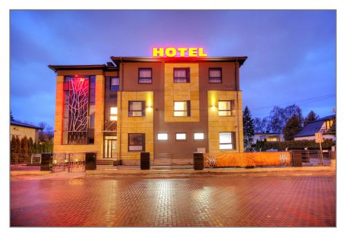 a hotel with a neon sign on top of it at Villa Park in Siedlce