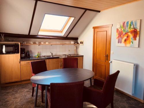 uma cozinha com mesa e cadeiras e uma janela em Appart Hotel Au Pied de Vigne em Vresse-sur-Semois